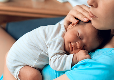 A mom holding their baby close to their chest